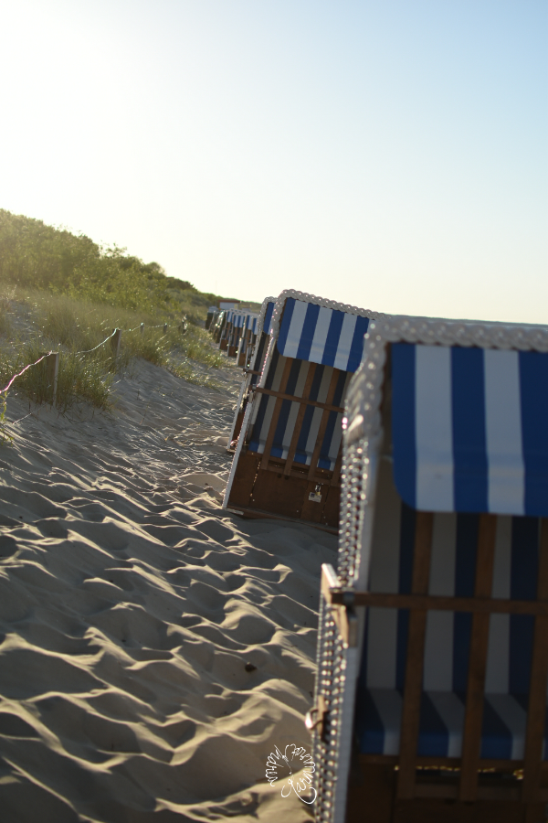 blau weiß gestreifte Strandkörbe am Deich