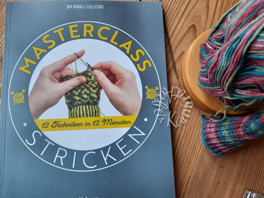 Strickbuch Masterclass stricken daneben ein paar angenadelte Socken